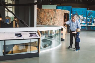 Man pointing out to child the exhibit of Monitor's turret.