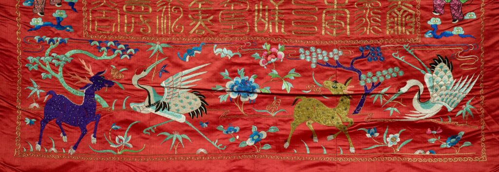 On the tapestry, flowers and trees are scattered among two cranes, a blue hooved creature with horns, and a golden hooved creature.