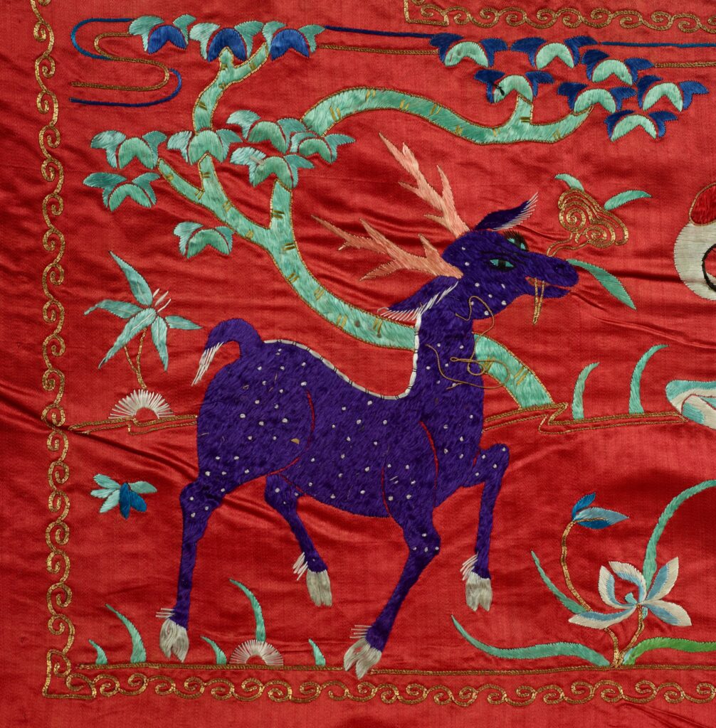 On the tapestry, a blue hooved creature with bronze-colored horns carries gold fungus in its mouth.