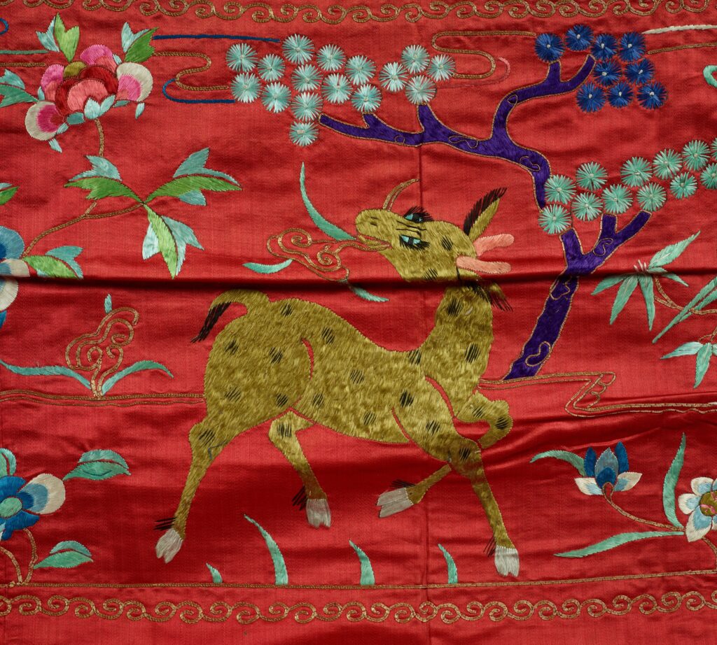 On the tapestry, a golden hooved creature trots along the flowers and trees.