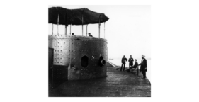 A picture of 4 men on deck outside of a turret looking into the turret at 2 men.