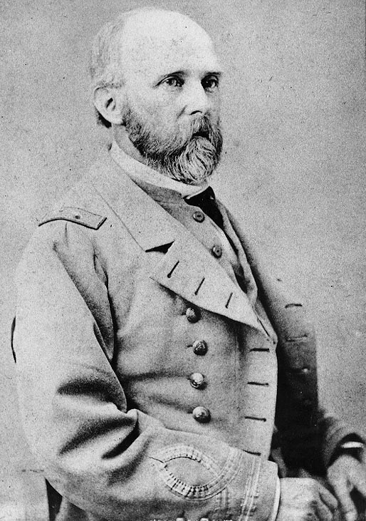 A black and white portrait of a man with a beard in a suit.