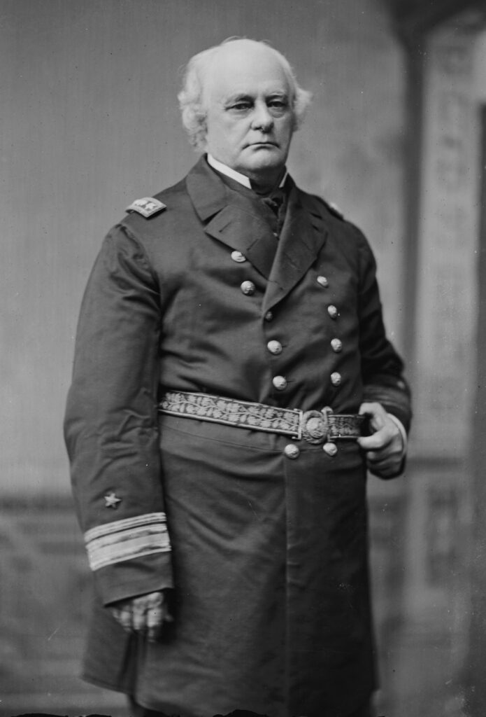 A photo of a man in a suit with gray hair.