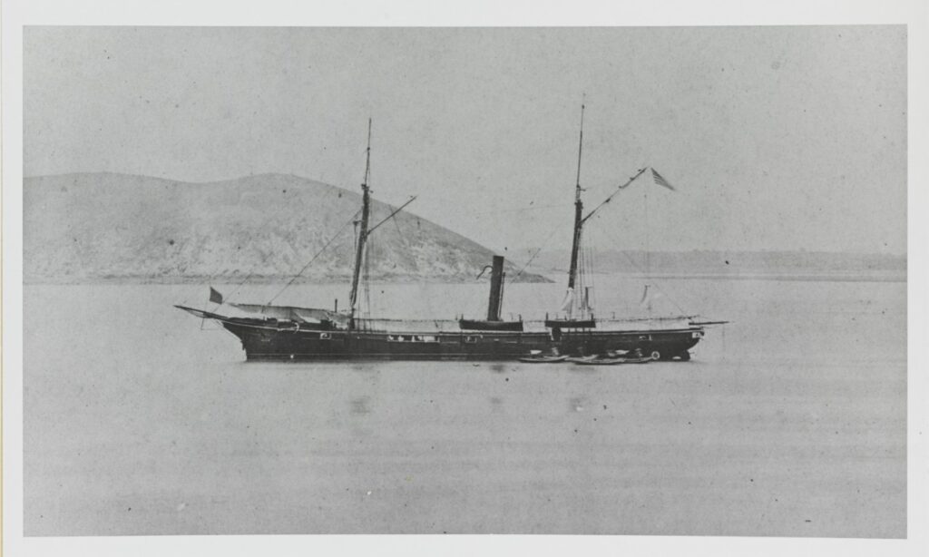 A photo of a ship on the water with a mountain in the background.