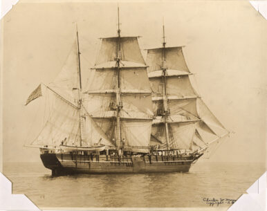 A sepia tone print of a ship with white sails on the water.